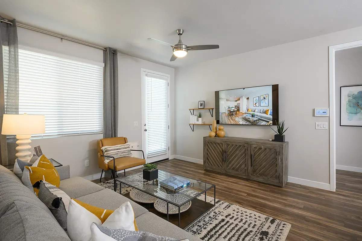 Furnished apartment living area shown — representative home at Village at Camelback Park.