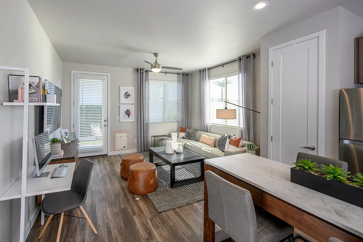 Furnished apartment living area shown — representative home at Village at Camelback Park.